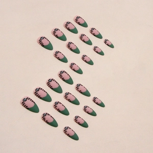Macro shot of matte dark green French almond nails with hand-painted leaf and vine patterns