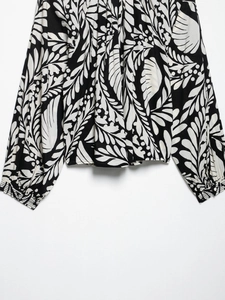 Detailed view of black and white botanical leaf prints on lightweight cotton-linen fabric