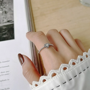 Close-up of vintage 925 silver heart ring with beaded edge on a model's hand
