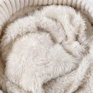 Thick cream knit beanie with plush fleece lining and ribbed cuff for winter warmth