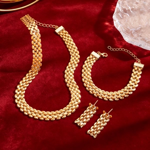 Golden watchband link jewelry set with necklace, bracelet and earrings on red velvet
