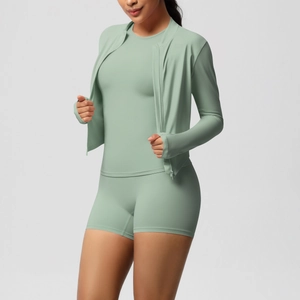 Three-piece yoga set in sage green showing zipper jacket, tank top and high-waist shorts