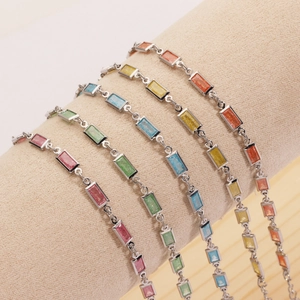 Vue détaillée de cinq bracelets de zircon colorés sur un support à bijoux beige