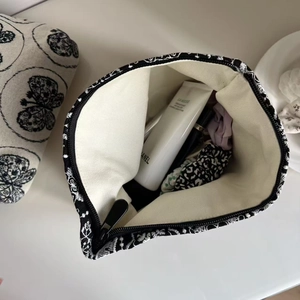 Top view of floral canvas makeup bag showing spacious interior with zipper closure