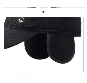 Close-up of black winter baseball cap with plush ear flaps and metal C YM logo detail