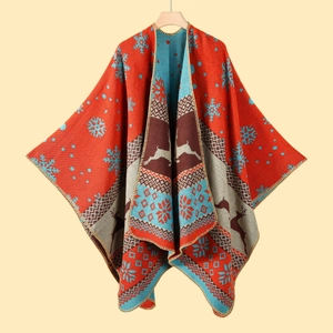 Detail of Christmas poncho with reindeer and snowflake patterns and tassel edges