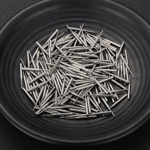 Precision machined stainless steel pins with stepped diameter design on a black plate