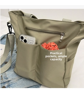 Detail of multi-functional tote bag showing side pockets for phone and umbrella storage