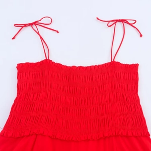 Detailed view of red smocked midi dress with adjustable self-tie ribbon shoulder straps