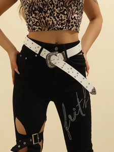 Close-up of white leather belt with vintage silver studs and buckle on leopard outfit