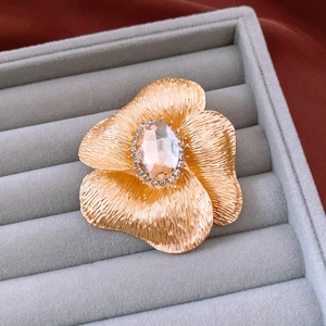 Detail view of vintage golden flower brooch with champagne gemstone on velvet
