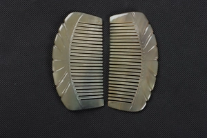 Macro shot of two carved semi-circle ox horn combs showing natural texture and finish