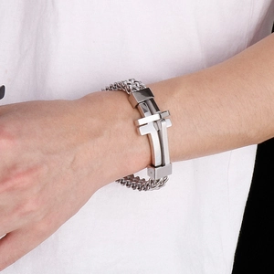 Macro shot of silver titanium steel curb chain bracelet with large H-shaped metal buckle
