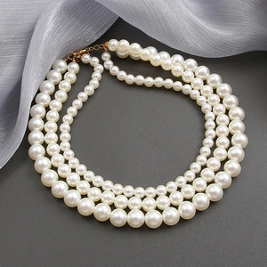 Three-layer faux pearl necklace with elegant triple-strand design and gold lobster clasp