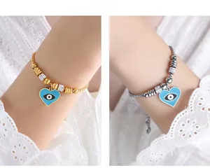 Detail of evil eye heart pendant bracelet in gold and silver with white zircon accents