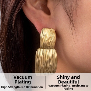 Detail of gold double-layered rectangular earrings with hammered vertical texture finish