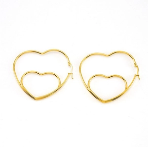 Detailed view of large gold hollowed-out double-layer heart earrings with metallic finish