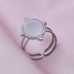 Detail of silver stainless steel adjustable ring with white round inlay on purple silk