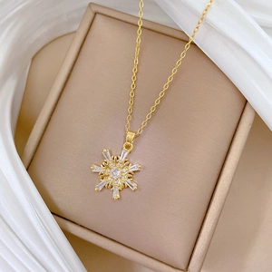 Detailed view of a gold snowflake pendant with sparkling crystals on a silk background