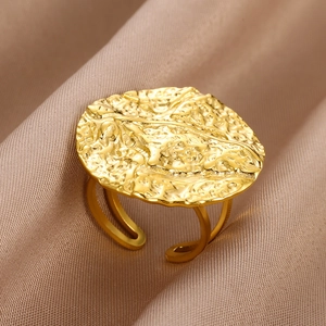 Detailed macro view of gold vintage ring with hammered texture on champagne silk