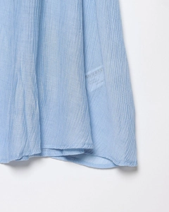 Détail de l'ourlet du gilet tricoté bleu clair avec texture plissée fine et coutures soignées