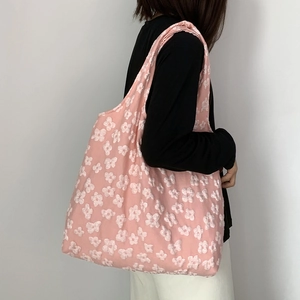 Close-up of pink 3D flower lace pattern on fabric tote bag shown on woman's shoulder