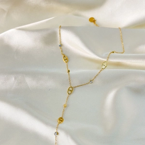 Close-up of gold plated Y-shaped necklace with oval hollow links and zircon accents