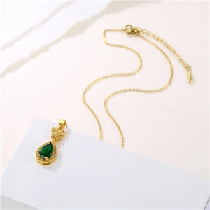 Gold titanium necklace with green pear-shaped crystal pendant and zircon butterfly bow detail