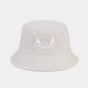Close-up of monster face embroidery on a beige cotton canvas bucket hat for Halloween