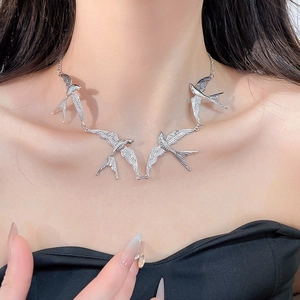 Silberne Schwalben-Halskette am Modell zeigt das Flügeldesign und Perlen-Details