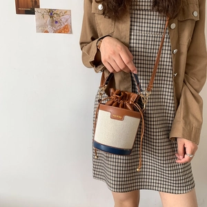 Retro canvas and leather bucket bag with drawstring closure and stylish color-block design