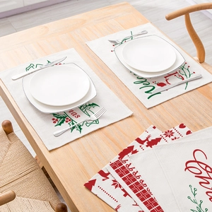 Christmas cotton linen placemat with festive red green print on a wooden table