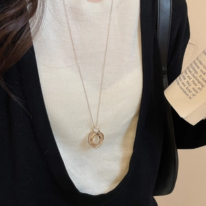Detailed view of 18k gold plated triple interlocking ring pendant on long sweater chain