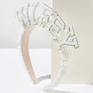 Elegant white birthday headband with faux pearls and rhinestones on a minimalist pedestal