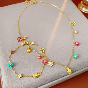 Detailed view of golden flower and ladybug pendant necklace and bracelet jewelry set
