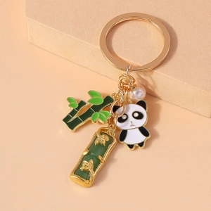 Close-up of cute panda keychain with green enamel bamboo charms and a white pearl detail