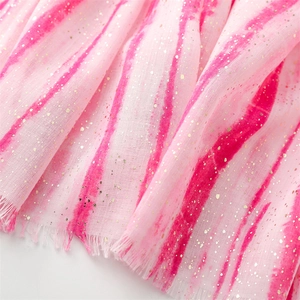Close-up of pink tie-dye fabric with golden sequins and tassel fringe detail