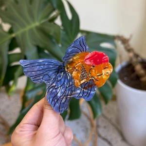 Detail of goldfish hair claw clip made of acetate with blue tail and orange body