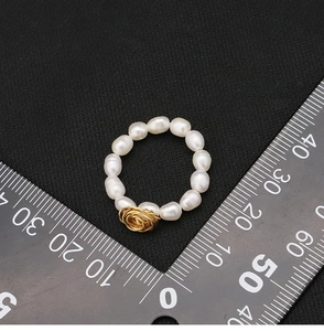 Misura dettagliata delle dimensioni dell'anello rosa di perle con filo d'oro e righello