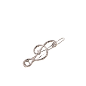 Detail of silver musical note hair clip with white pearl and rhinestone embellishments