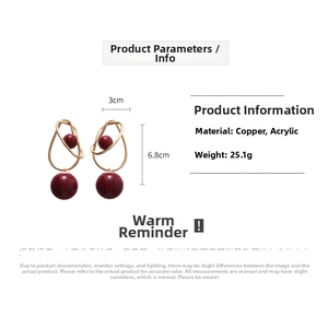 Detailed size view of acrylic red bead earrings with golden wire wrap design