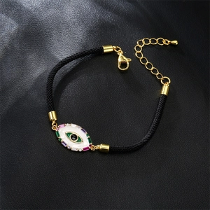 Close-up of gold-plated Evil Eye bracelet with colorful cubic zirconia on black leather