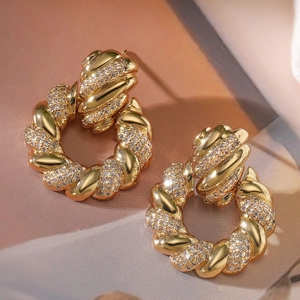 Detail shot of 18K gold plated twisted hoop earrings with sparkling zircon inlay