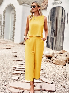 Detail view of a yellow two-piece summer set with sleeveless crop top and wide-leg trousers