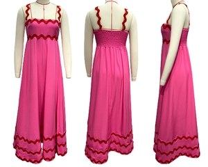 Detail of rose pink maxi dress featuring red wavy lace edges and elastic shirred back design