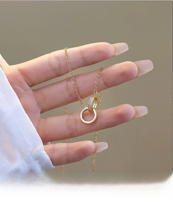 Detail showing interlocking golden double rings with crystal pave on a delicate chain