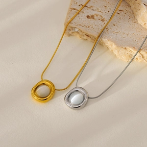 Gold and silver snake chain necklaces with round cat eye stone pendants on stone base