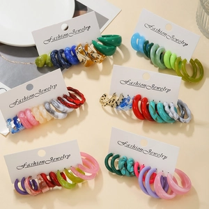 Détail de six ensembles de créoles colorées en résine acrylique en forme de C sur cartes