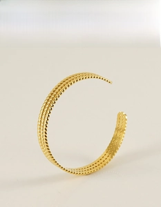 Détail de la texture tressée du bracelet jonc en acier inoxydable plaqué or 18 carats