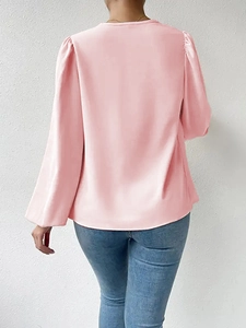 Rear view of a loose pink chiffon long sleeve blouse paired with blue denim jeans